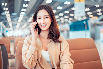 Happy asian tourist woman using mobile smartphone with suitcase traveling between waits for flight in Airport Terminal, Browse Internet, flight check in, Tourist journey trip concept