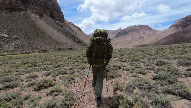 Person hiking with heavy backpack on the approach to basecamp on Aconcagua