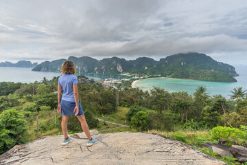 Woman standing on the viewpoint, in the background the two bays of the island of phi phi don in thailand