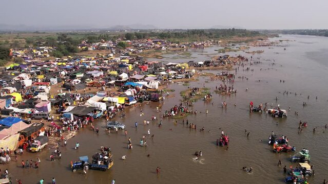 A huge crowd of people camped at the riverbank during a Hindu religious festival