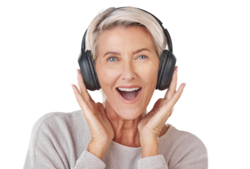 A happy mature woman wearing headphones to listen her favourite music.. A smiling caucasian senior enjoying the loud music and looking youthful and playful isolated on a png background.