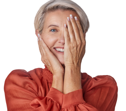 A happy senior with a hazel eye covering her half face in wellness. A gracious senior woman touching her perfect skin isolated on a png background.