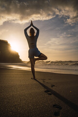 sporty woman stretching her shoulders on the beach.