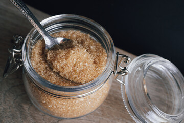 Natural cane sugar in glass jar and spoon on wooden table background - 571209346