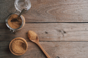 Natural cane sugar in glass jar and spoon on wooden table background