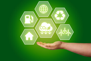 Woman hand showing eco life hologram interface. Reduce CO2 emissions to limit climate change and...