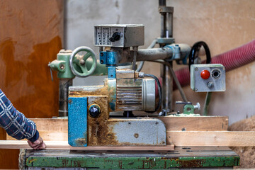 planing boards on a machine in a joinery. production of solid wood furniture