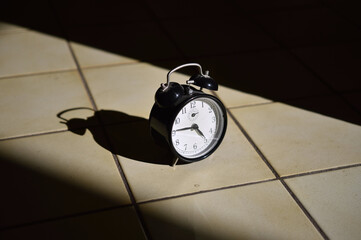 Vintage retro alarm clock with sharp sunlight and shadows 