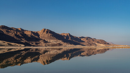 Fototapeta na wymiar The beautiful Judean desert mountains reflected in the Dead Sea at Ein Bokek, Israel. 