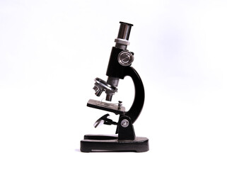 Side view of vintage microscope with white background