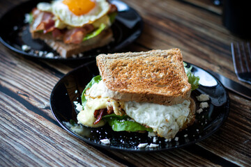 
A fresh and healthy toasted sandwich made from fresh vegetables. Sandwich with eggs and bacon.