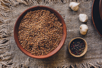 Raw buckwheat in earthenware in a rustic setting. Top view.