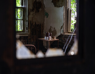 Looking through the shattered glass of a doorway in an abandoned building