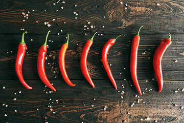 Red hot chili peppeprs on dark wooden background