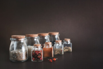Various herbs and spices in round and square glass jars. Environmentally friendly cork lids.