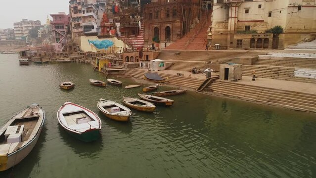 Aerial view of empty boats at Ganga Ghat in Banaras city at sunrise in slow motion high frame rate