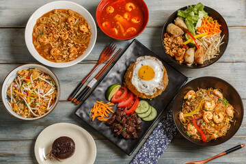 Composition des plats asiatique dans une vaisselle colorée, servie sur fond rustique bleu, vue de dessus. Ensemble de cuisine chinoise, vietnamienne, thaïlandaise.  - obrazy, fototapety, plakaty