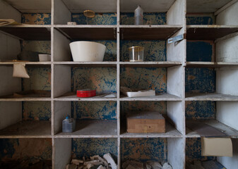 Fototapeta na wymiar Bowls and other unique items on a shelf in an abandoned hospital