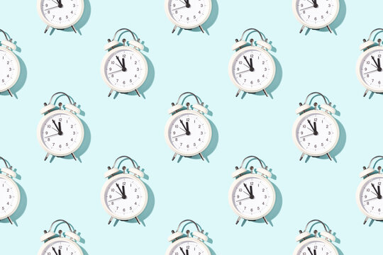 Seamless pattern of white alarm clocks on bright light blue background. Conceptual sunlight background.