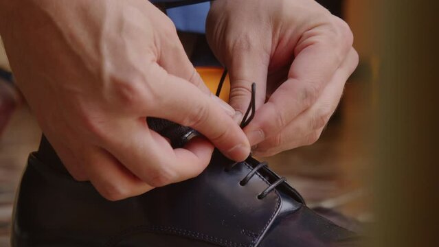 Man tying patent leather shoes