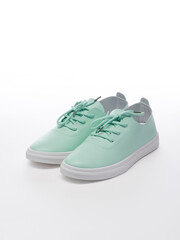 Pair of leather sport shoes on a white background. Isolated turquoise sneakers with shadow
