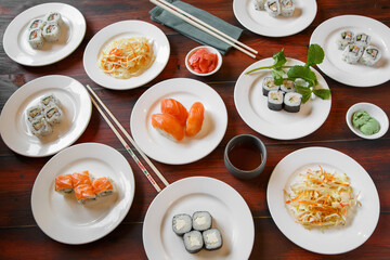 Composition des plats japonais, servie sur fond rustique foncé, vue de dessus. Ensemble de cuisine japonaise. Assortiment de sushi. Buffet à volonté