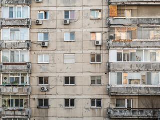 Worn out apartment building from the communist era against blue sky in Bucharest Romania. Ugly traditional communist housing ensemble