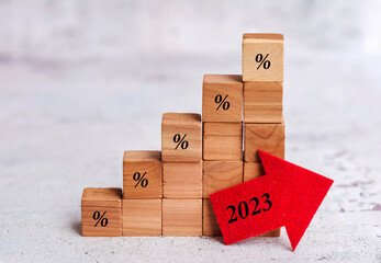 Wooden  cubes with 2023 year word and red up arrow .Increasing  inflation concept