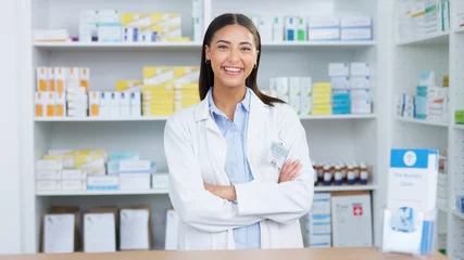 Poster Portrait of a cheerful and friendly pharmacist using a digital tablet to check inventory or online orders in a chemist. Young latino woman using pharma app to do research on medication in a pharmacy © Nina L/peopleimages.com