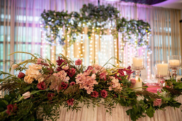 Wedding flowers set up in a restaurant. A wedding colorful bouquet arrangement on the table with white table cloth. High quality photo