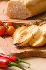 White toasted bread with rosemary hot peppers, cherry tomatoes on table.