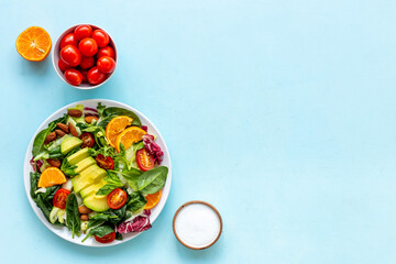 Bowl of green salad with avocado and tomatoes. Healthy vegetarian lanch