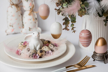 Fototapeta na wymiar Banner. The concept of a bright Easter holiday. A bouquet of flowers with feathers, white rabbits and Easter eggs in a plate on a white isolated background. Beautiful Easter card.