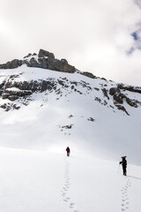 Snow hiker walking in a snowy hillside in a cloudy day