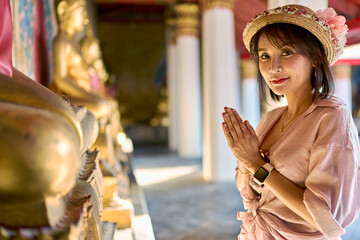 thai woman praying and making wai at wat arun temple in bangkok thailand