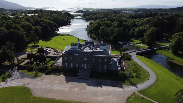 Slow aerial orbit of Georgian estate in Irish countryside next to mountains and river