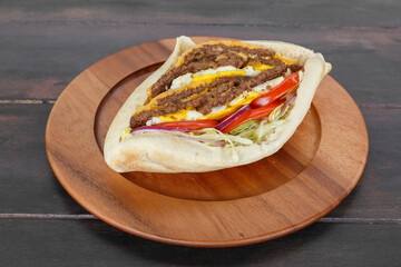 Sandwich triple steak maison dans une assiette sur une table en bois. Döner Kebab gros plan.