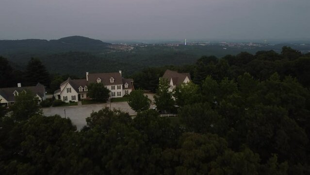 Aerial flight over trees revealing houses in Branson, MO.