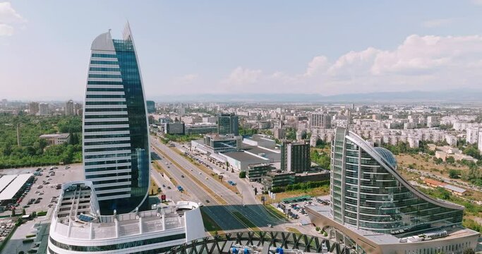 Skyscraper in new &ldquo;Capital City&rdquo; complex aerial view drone. Exterior view of office building with glass facade summer sun day. Skyscraper under construction. Rent