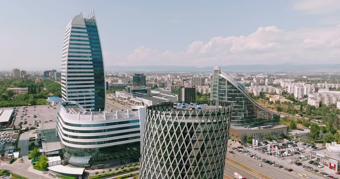 Skyscraper in new &ldquo;Capital City&rdquo; complex aerial view drone. Exterior view of office building with glass facade summer sun day. Skyscraper under construction. Rent