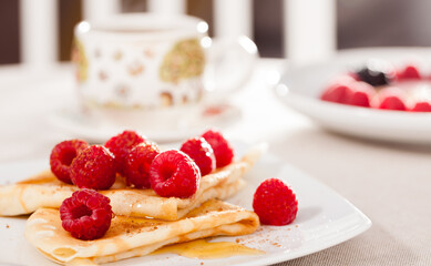 breakfast of pancakes with fresh raspberries on table