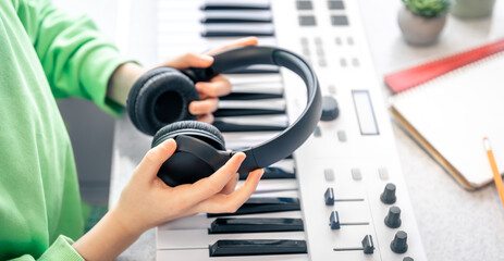 Close-up, black headphones in the hands of a child, music concept.