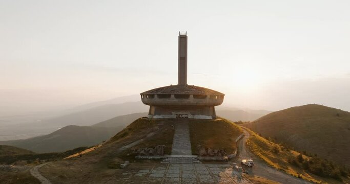 Buzludzha Memorial House in Bulgaria. Monument symbol to Communism on top of mountain sunset summer drone flyby areal view. Kazanlak Monument House Bulgarian Communist Party