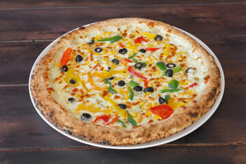 Pizza orientale épicée fait maison dans une assiette sur une table en bois. Gros plan.