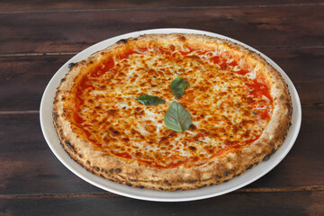 Pizza Margherita fait maison dans une assiette sur une table en bois. Gros plan.