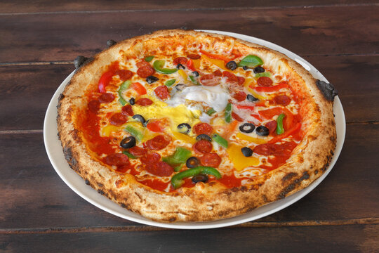Pizza orientale épicée fait maison dans une assiette sur une table en bois. Gros plan.