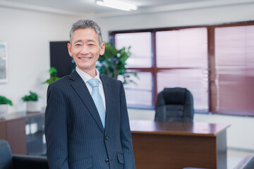 役員室で腕を組む経営者