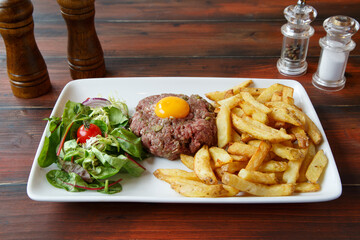 Tartare avec des frites et la salade