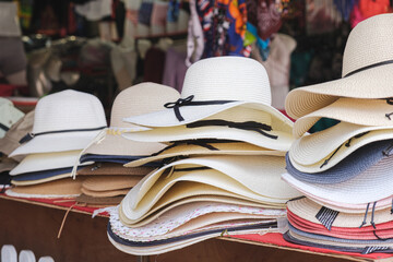 Counter of a street seller of hats in a resort place. A variety of woven hats for women and men are...