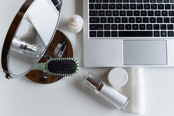 Workplace - a laptop on a white background and cosmetics